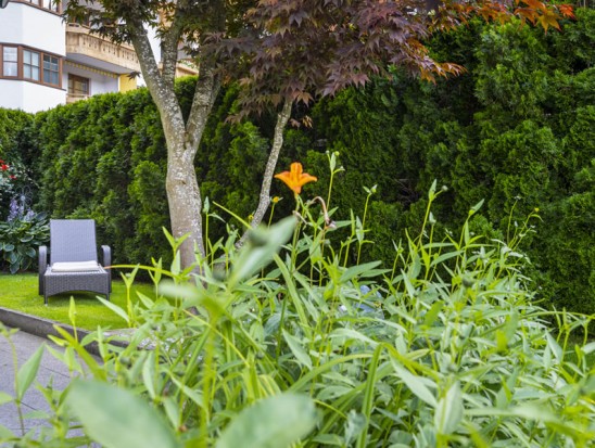 Blumenschmuck und Sonnenliege im Garten